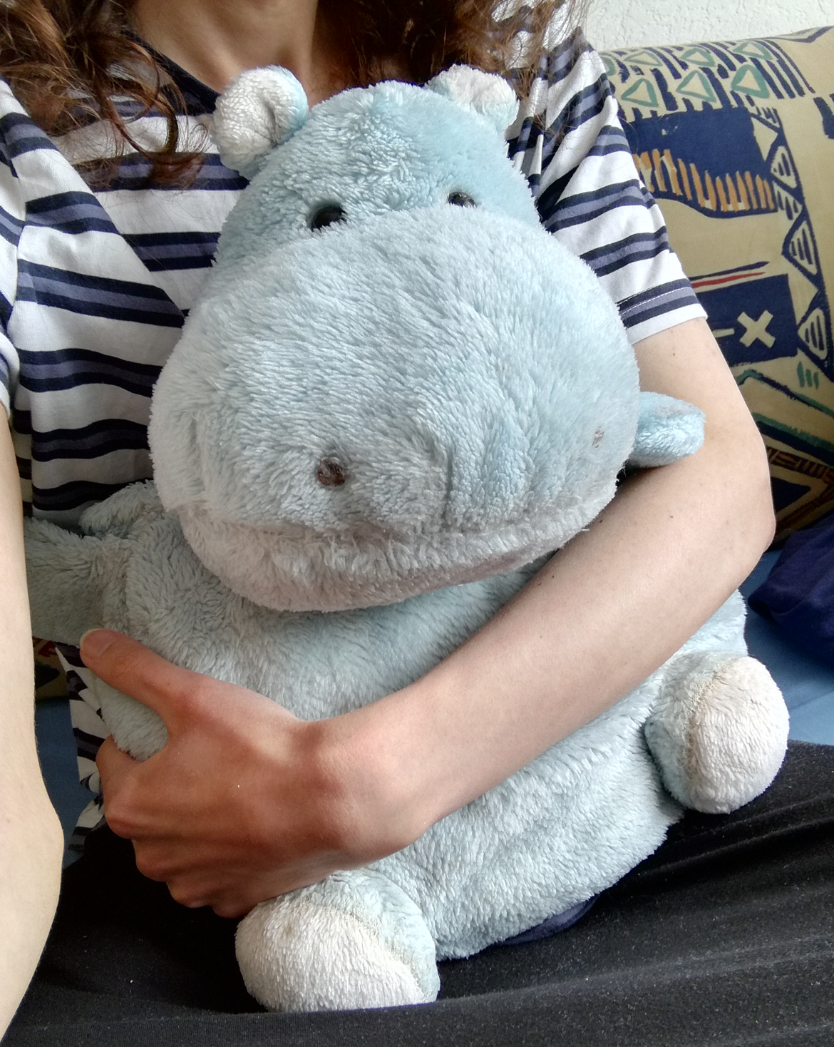 Me holding a slightly grimy, light blue hippo plushie